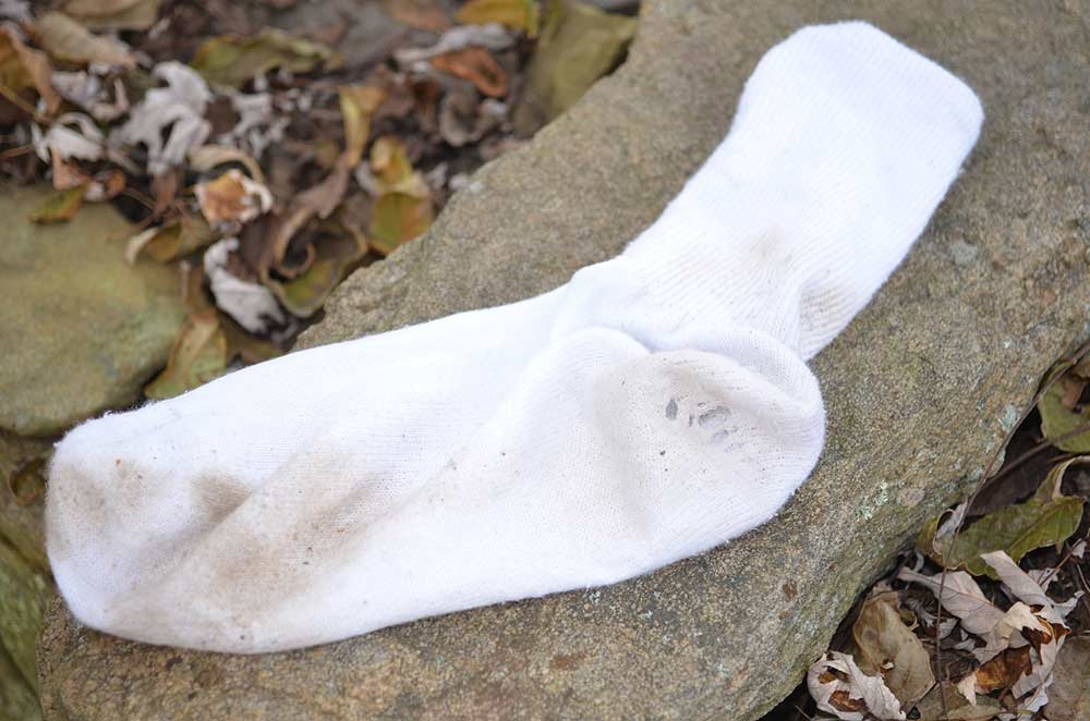 a dirty cotton sock on a rock
