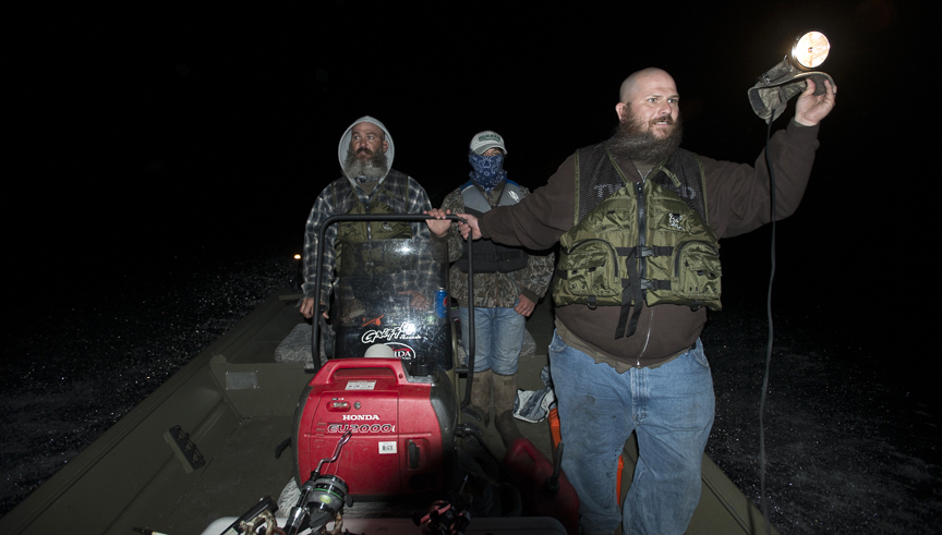 <em>Shanon Lanphar (left) motors across Table Rock to a new finger of the lake in search of fish while Travis scans the water with a jerry-rigged headlamp.</em>