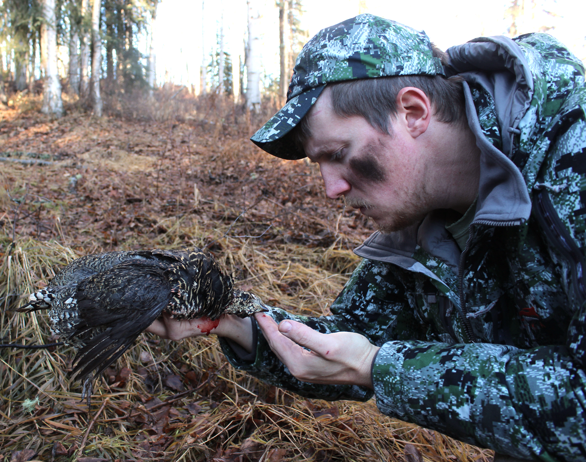 A satirical photo of a hunter with a dead grouse.