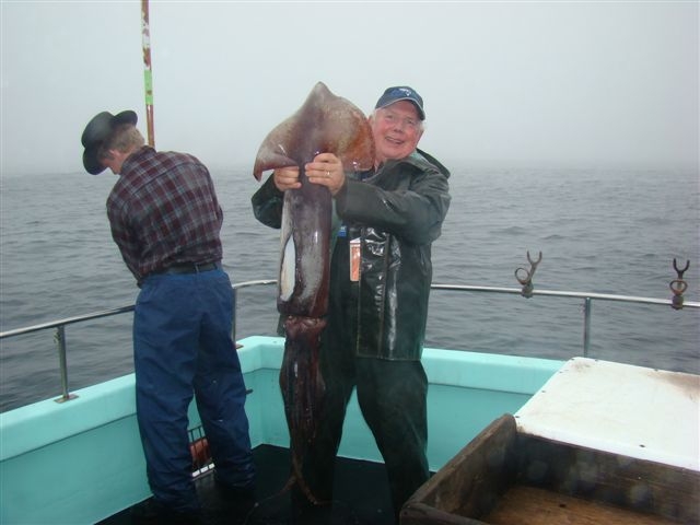 An angler holds up a squid