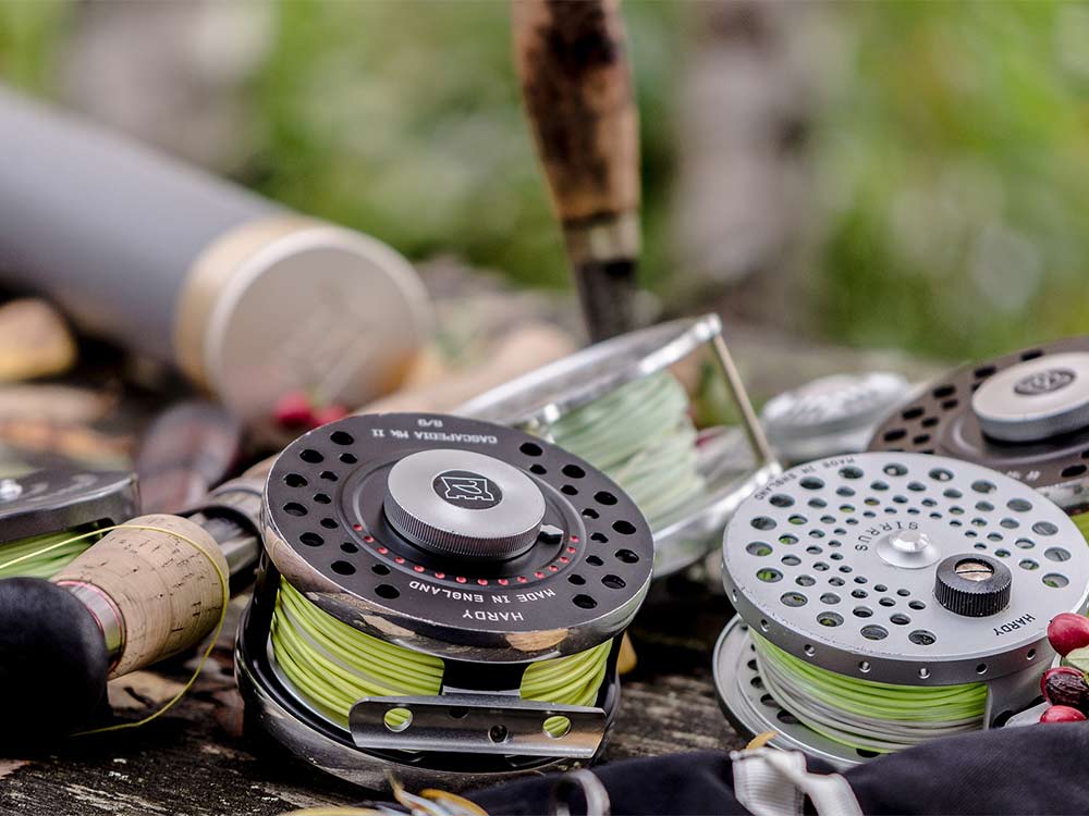two fly fishing reels on the ground