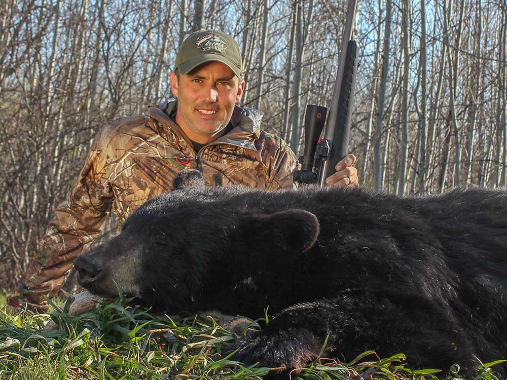 a summer hunter next to a black bear