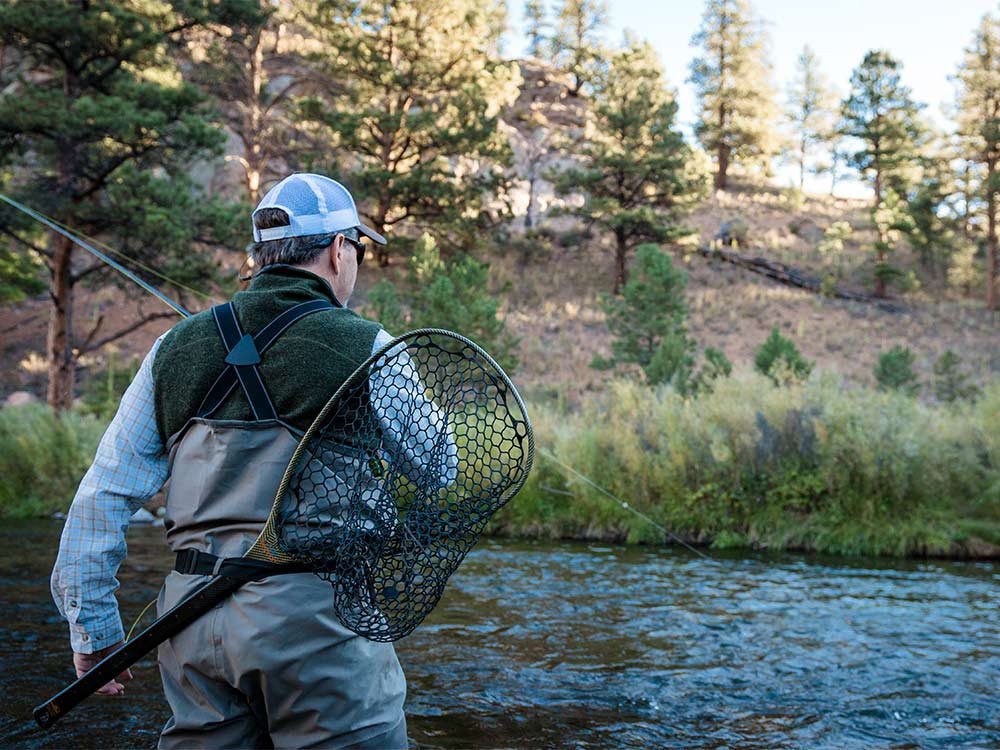 fly fisherman with net on back