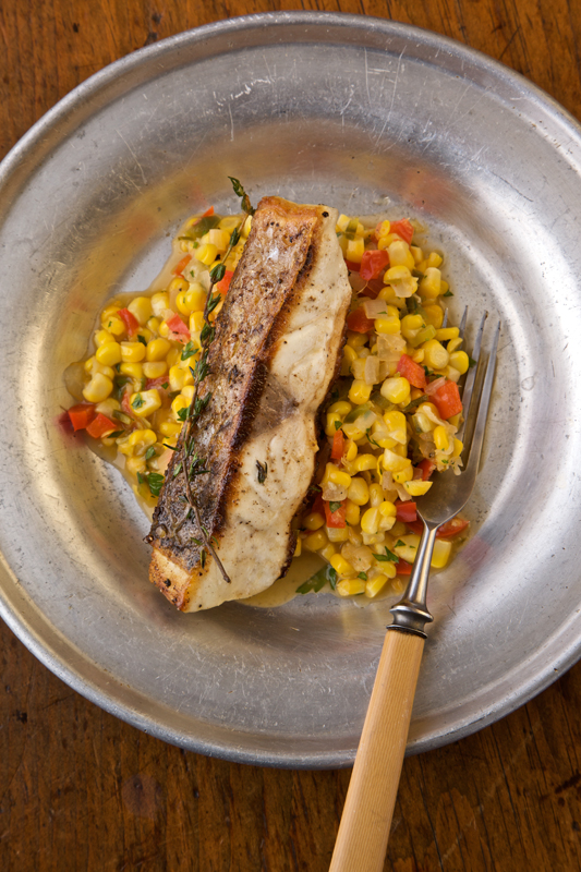 <strong>Roasted Striped Bass with Corn Relish</strong><br />
(serves 4)<br />
2 Tbs. peanut oil<br />
4 1-inch-thick, center-cut striped bass fillets (about 6 oz. each), skin on<br />
Kosher salt and freshly ground black pepper<br />
3-4 Tbs. unsalted butter<br />
2 sprigs fresh thyme<br />
Coarse sea salt Directions<br />
1. Heat the oil in a large skillet over medium heat until it slides easily across the pan. Dry the fillets thoroughly with paper towels, season them with Kosher salt and pepper on both sides, and then add them, skin-side down, to the skillet. 2. Reduce the heat (the oil should sizzle, not sputter) and cook the fillets until the skins are crisp, about 3 minutes. Turn the fillets and gently brown the other side, about 3 minutes more. 3. Add the butter and thyme. Continue cooking the fillets, turning them once or twice (so they brown evenly) and basting with the lightly browning butter. Cook until the fish is opaque, about 4 minutes. Serve at once drizzled with the browned butter and sprinkled with coarse sea salt. Chef's note: Any firm-fleshed fish (halibut, cod, snapper, salmon, grouper) may be substituted. Just make sure the fillets are about 1-inch thick, or adjust the cooking time accordingly.
