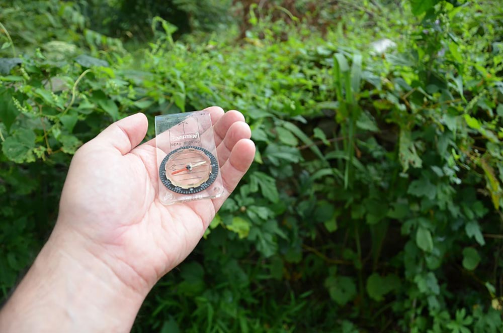 hand holding up a plastic compass
