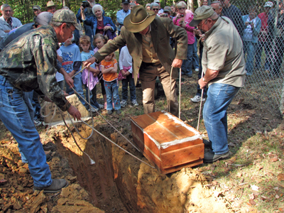 With a group of children standing by the dog's headstone, the simple wooden casket containing the mortal remains of "The Merch" was lowered into the ground. Photo by Janice Williams, Colbert County Tourism