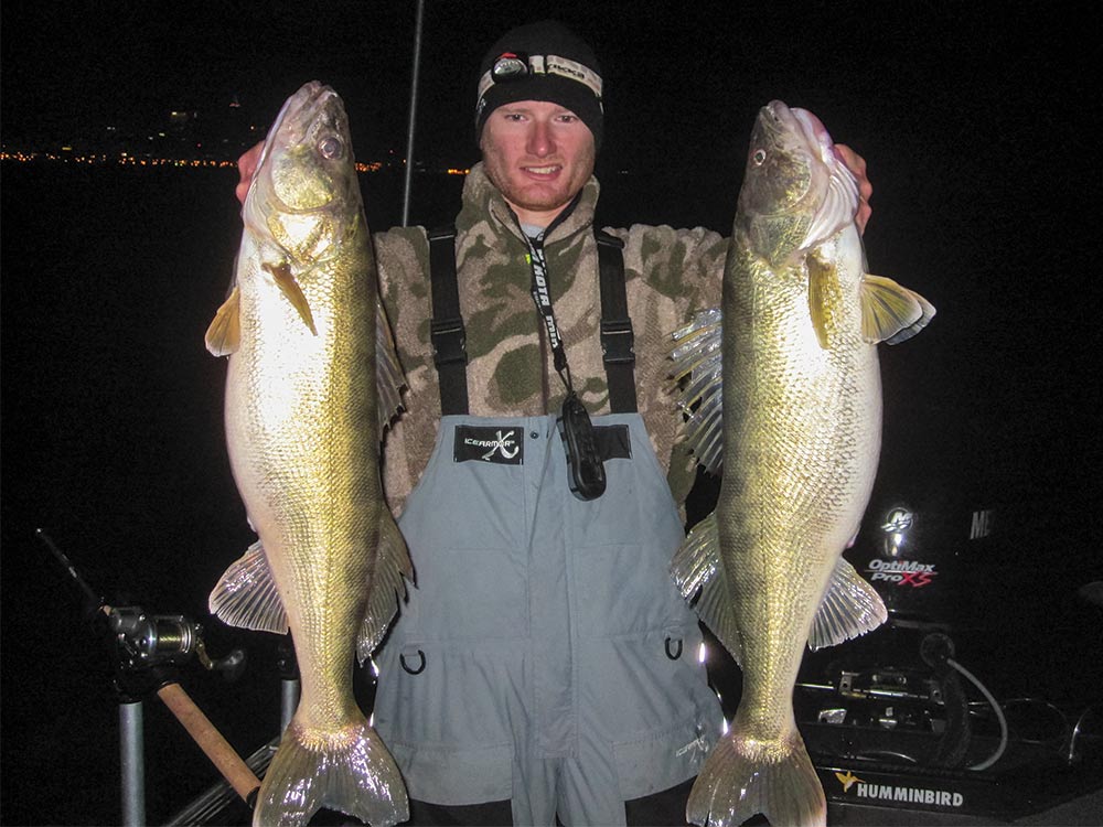 fisherman holding up two walleye