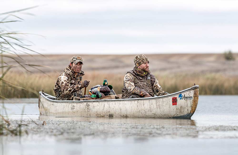two waterfowl hunters in a canoe