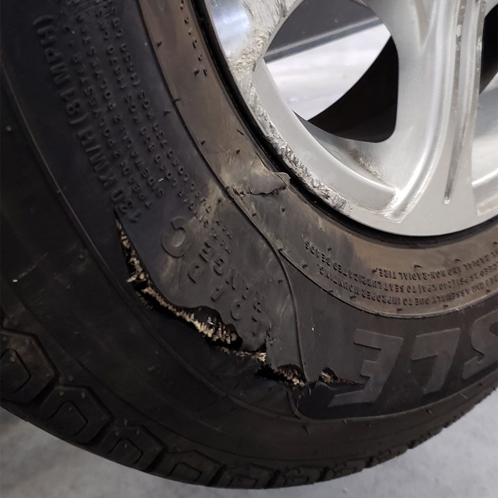 a trailer tire with a dry rotted tear