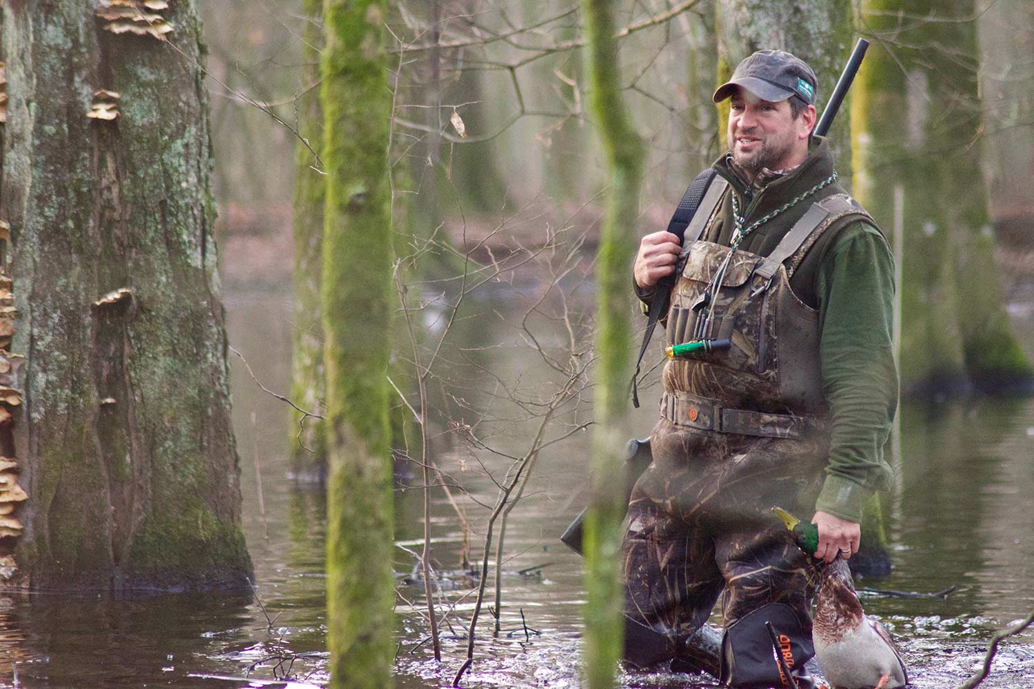 A hunter wading through flooded timber while duck hunting.