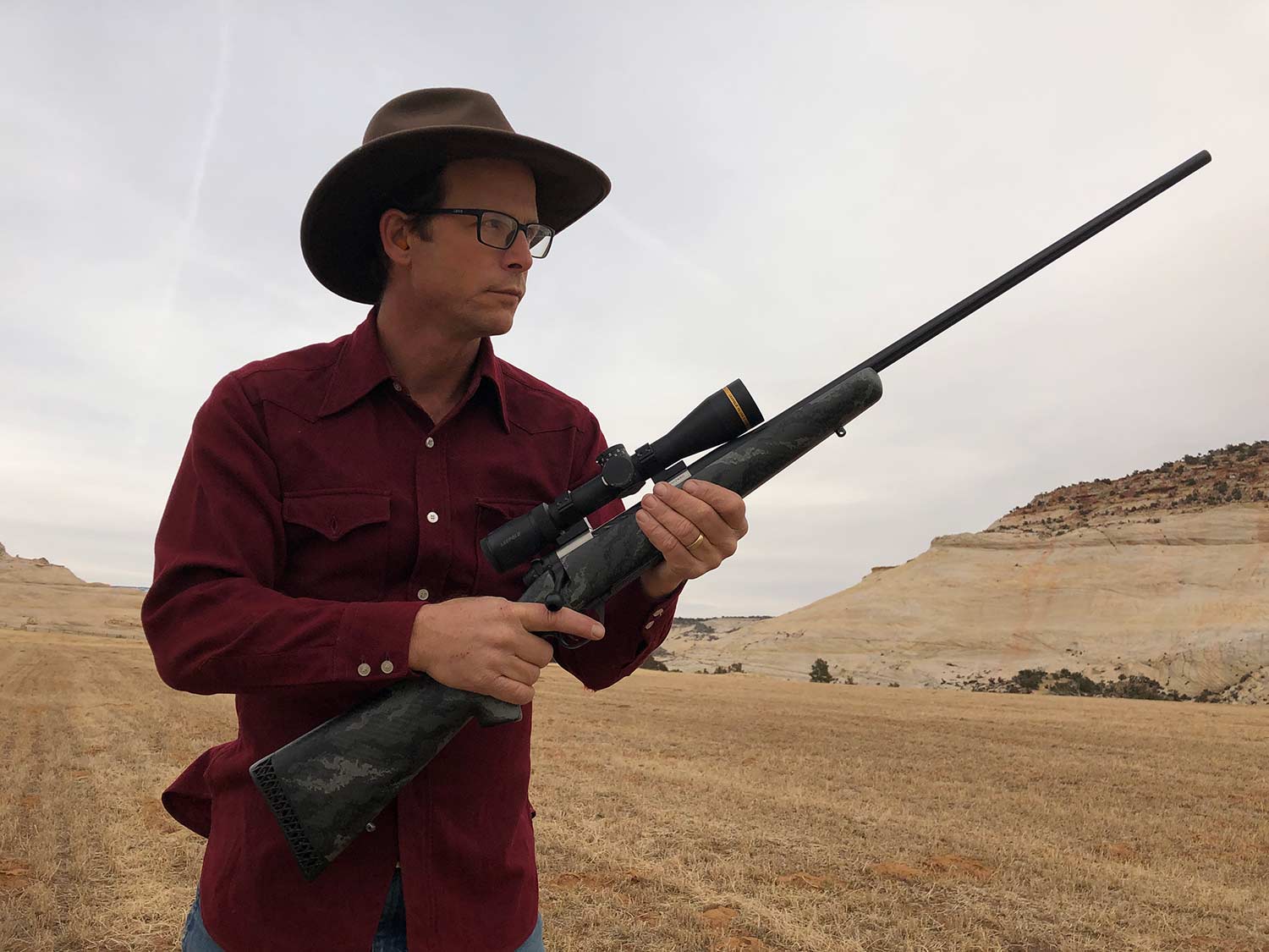 Man in cowboy hat holding a Weatherby Backcountry rifle.