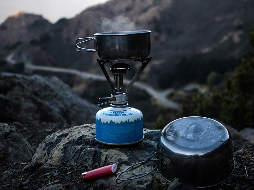 outdoor stove and cookpot on a rock.