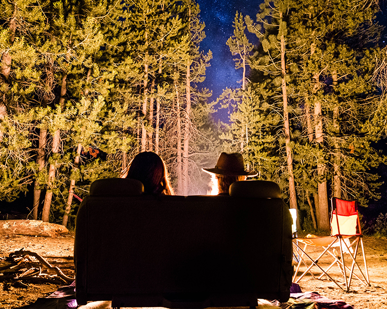 two people in a camping chair at night.