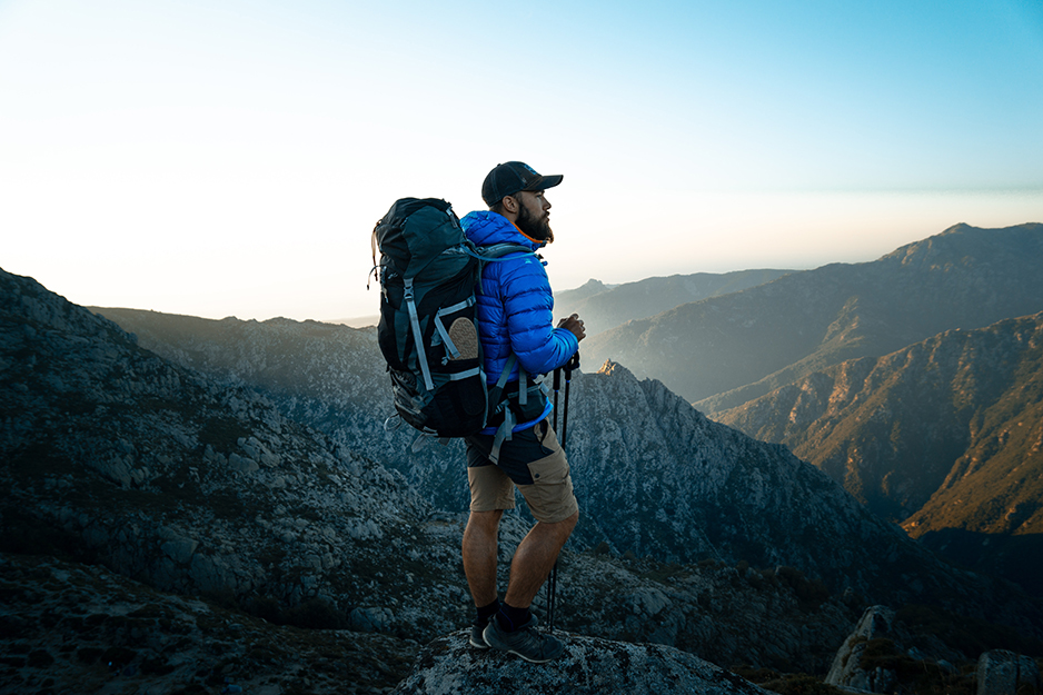 Guy on a mountain wearing a backpack
