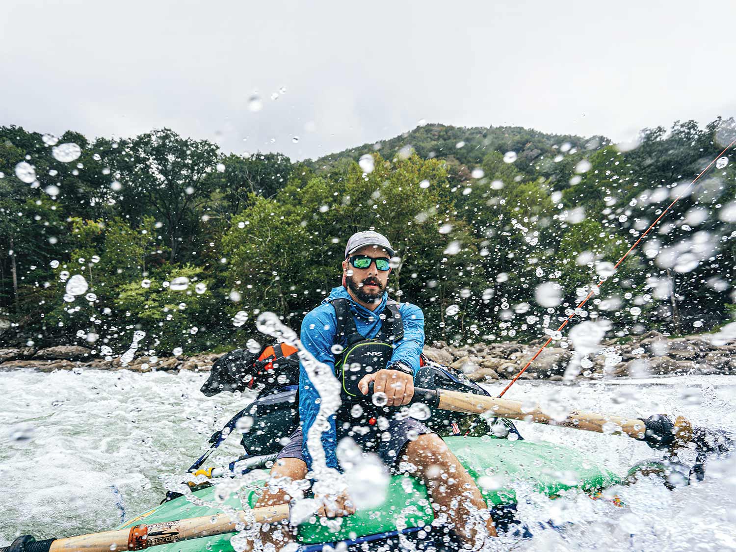 Man whitewater rafting down a river.