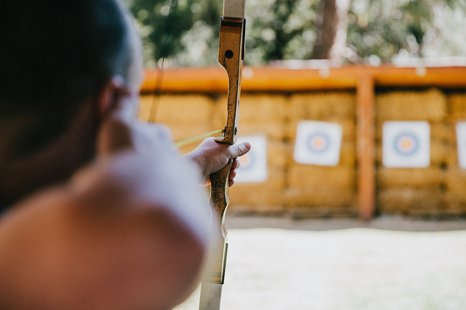 person aiming at archery target