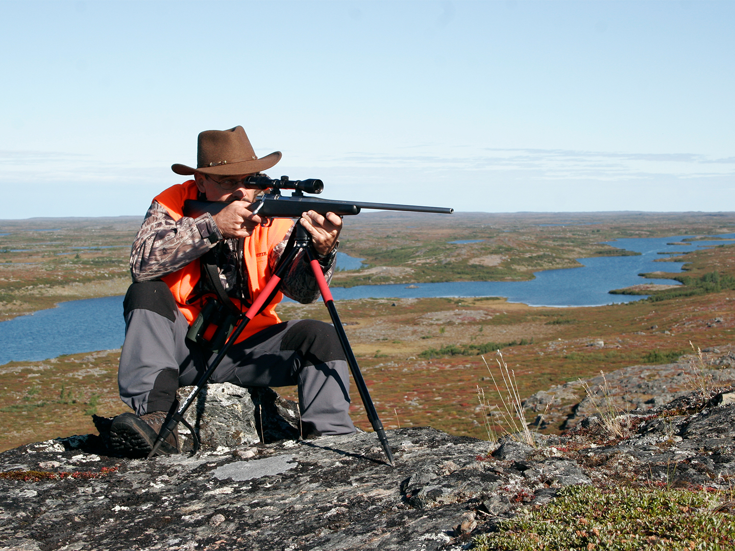 Hunter aiming a rifle using a bipod.