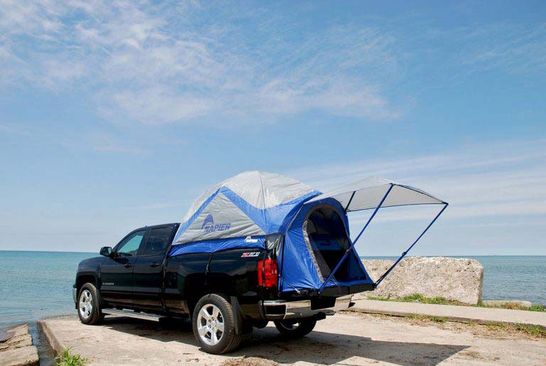 A truck outfitted with a tent in the truck bed.