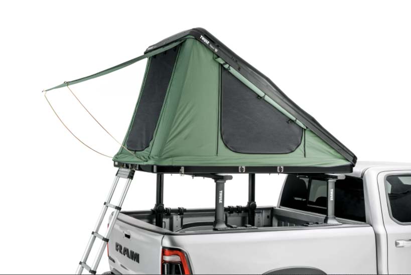 A box wedge camping tent in the bed of a white RAM truck.