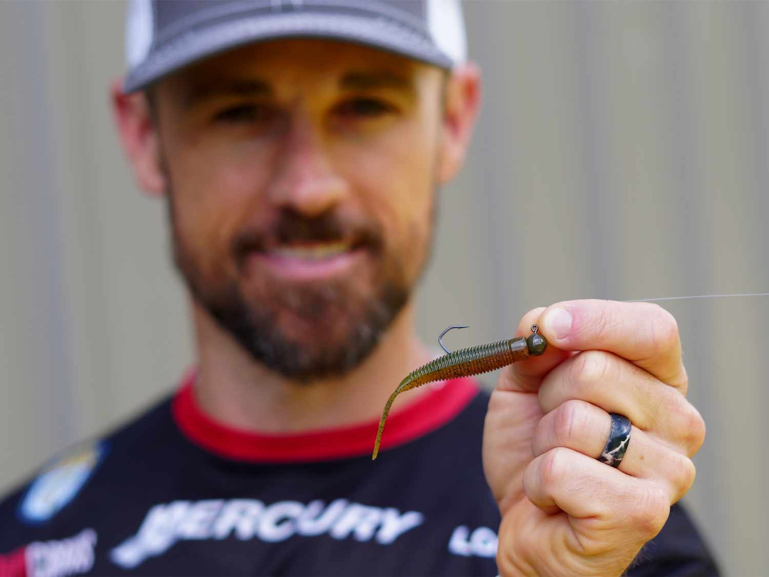 A bass fishing angler holding up his favorite fishing ned rig.