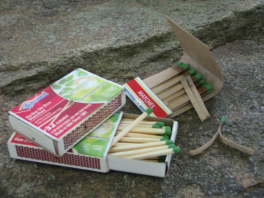 A box and a book of matches on a rock.