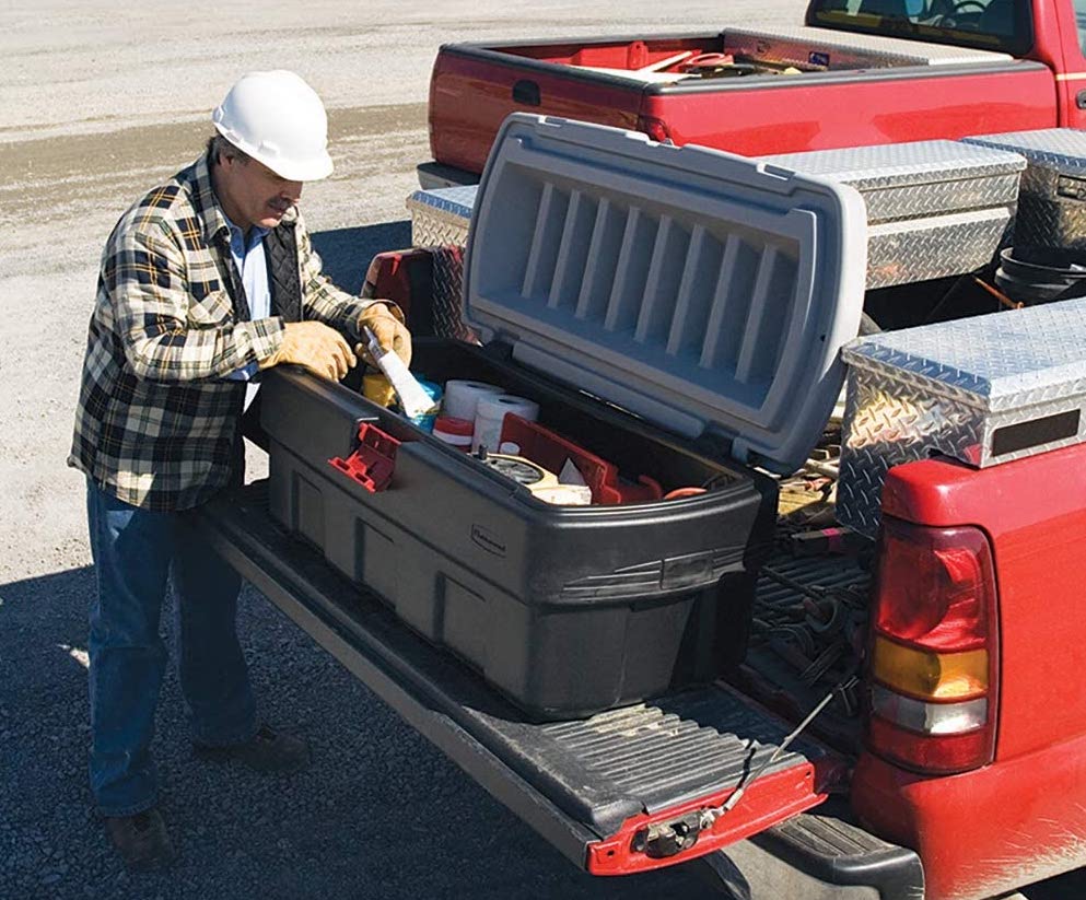 Man opening one of the best storage bins in the back of his truck