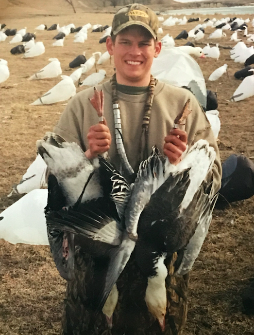 Tyson Keller with two blue geese after hunting in a traditional socks spread.