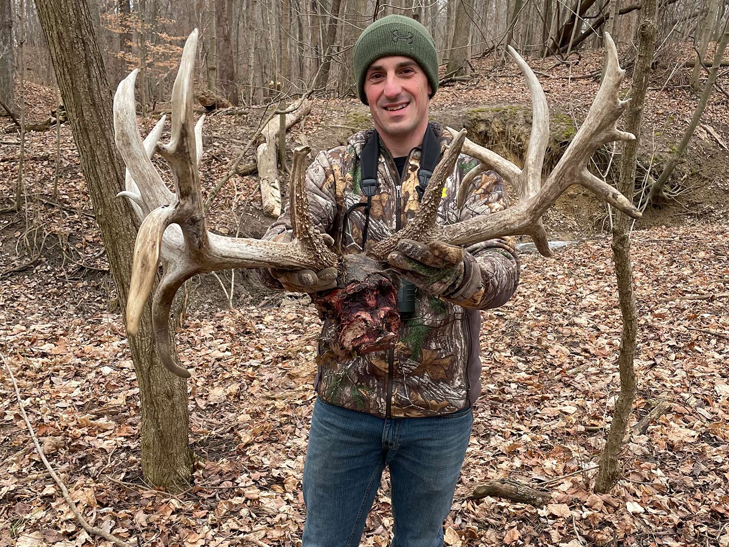 A hunter holds up a shed deer antlers.