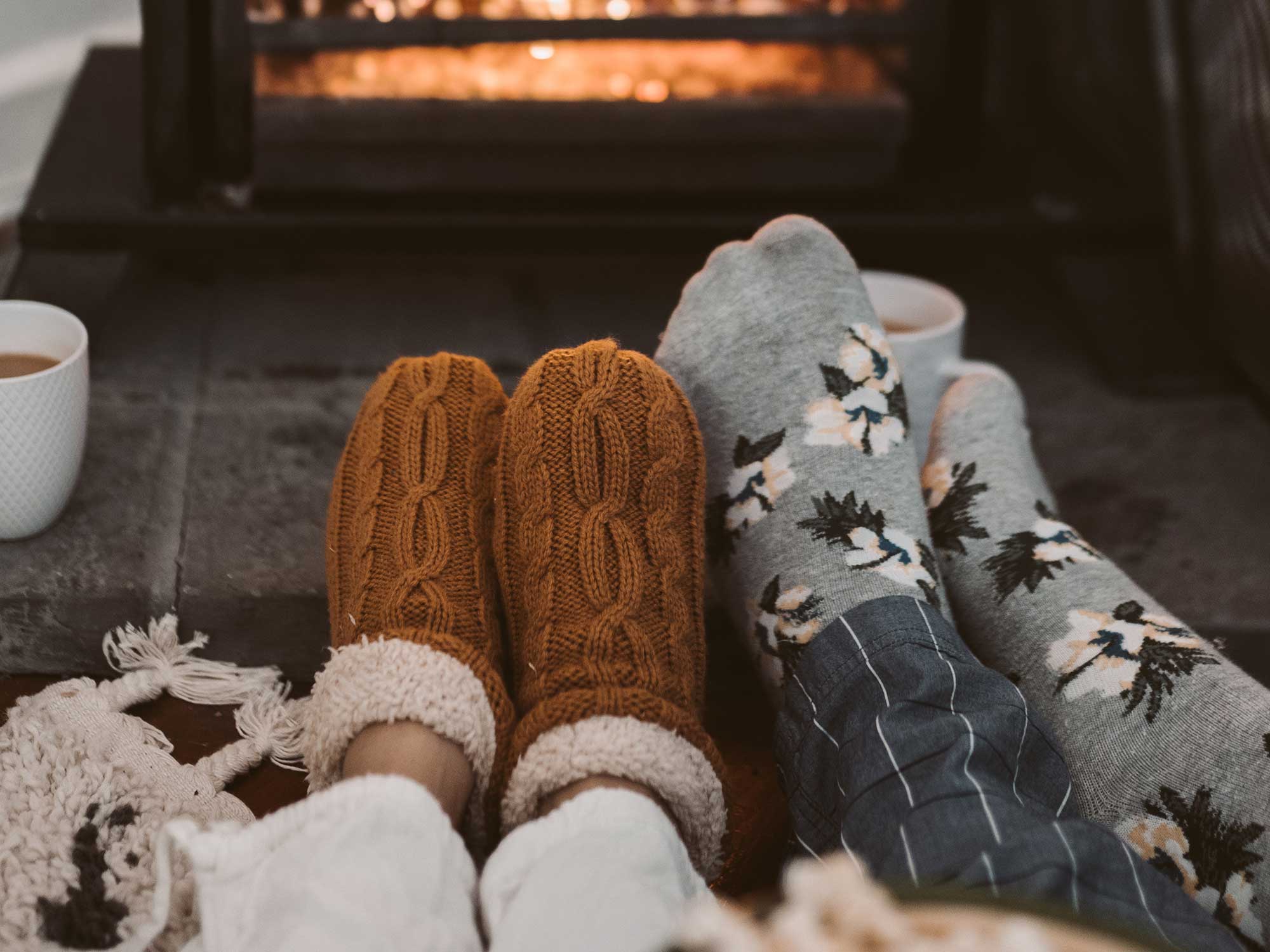 People wearing slipper socks by a fire