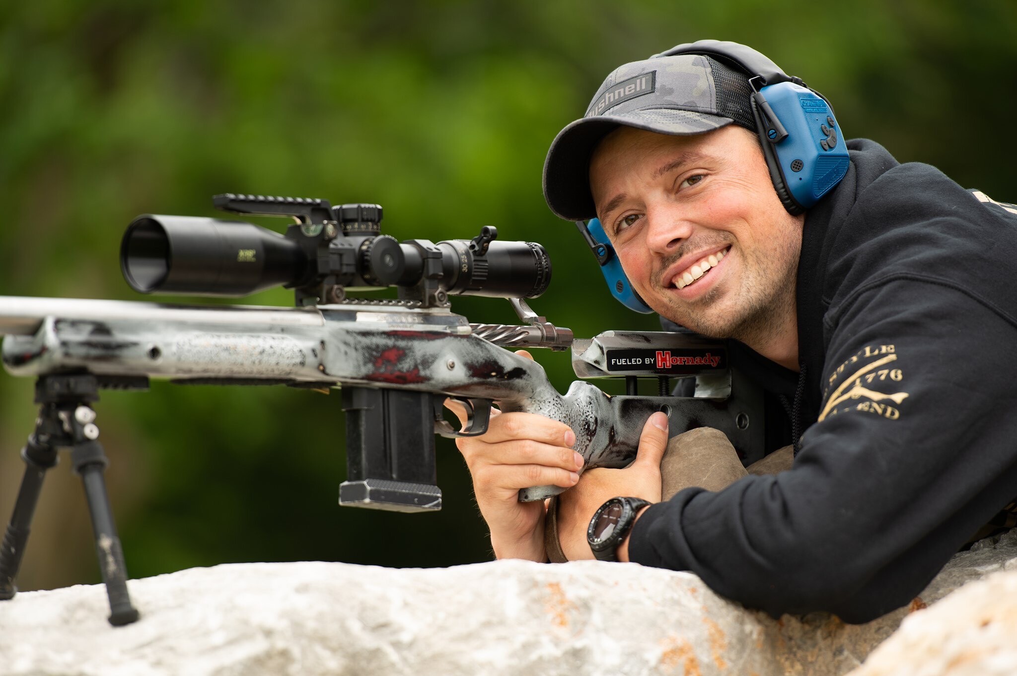 A competitive shooter behind a rifle on a bipod, having fun and not worrying about performing well in a competition.
