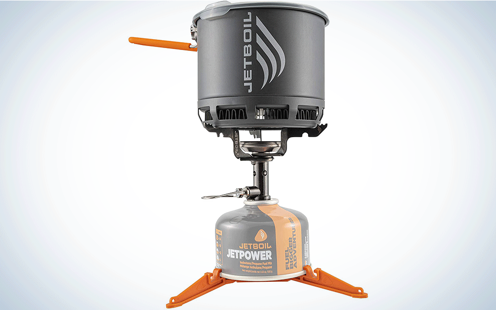 A backpacking stove with a fuel canister and grey pot