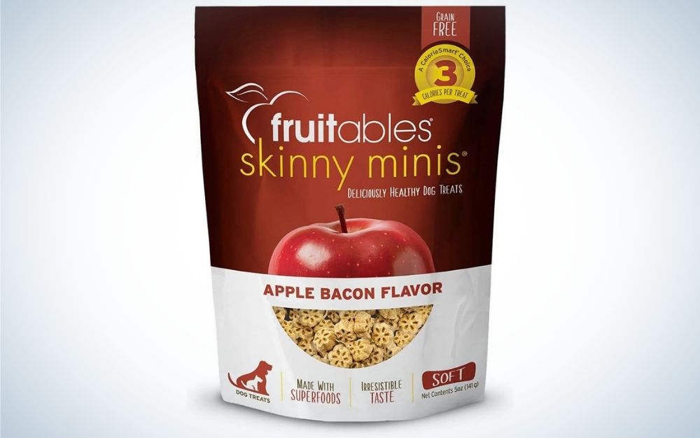 A cherry color nd white packing of a fruitables skinny minis' dog treat with a half apple and bacon flavor under it.