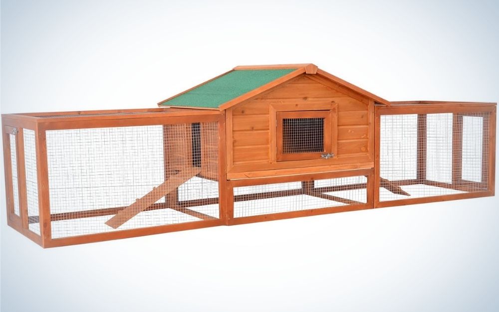 A large wooden rabbit hutch pet house with ramps, lockable doors, run area and green asphalt roof for outdoor use.