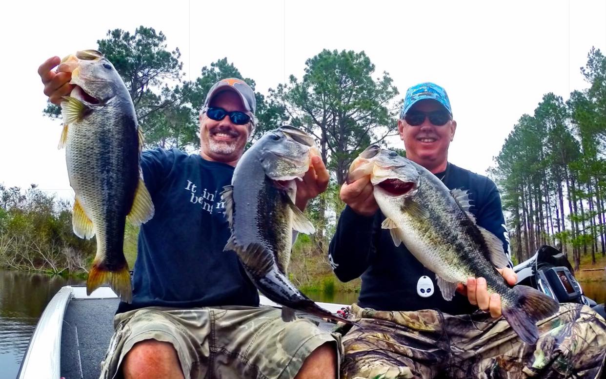Two bass anglers with big florida-strain fish.