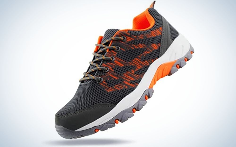 Thick gray hiking sneakers with gray laces with orange dots and gray, white and orange rubber.