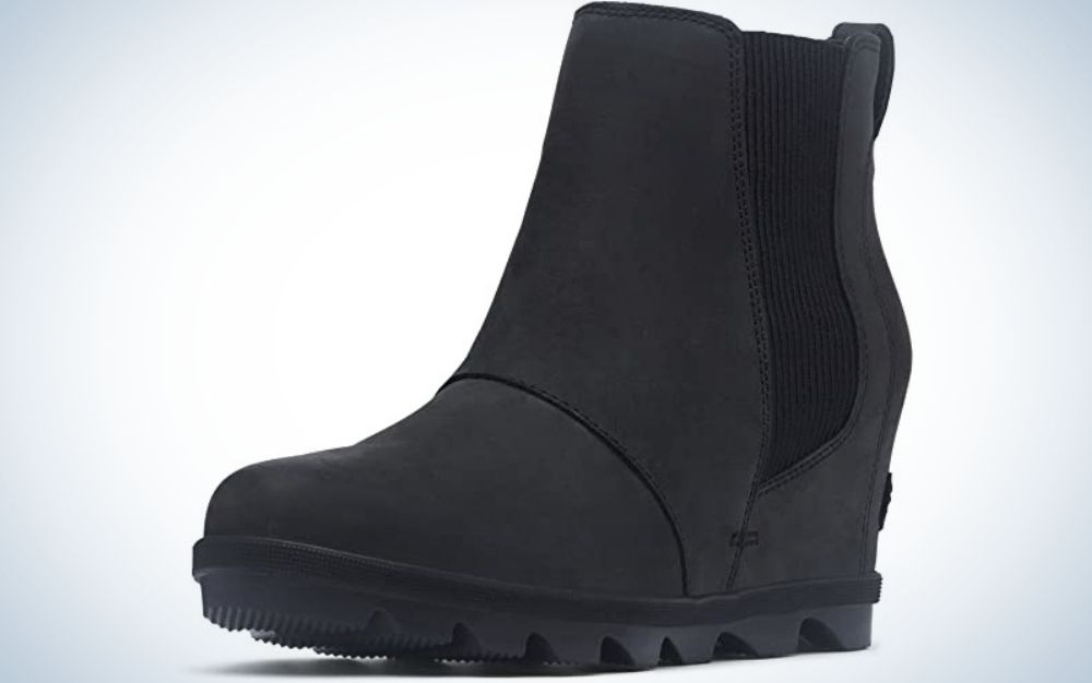 A black boot made entirely of suede material and with the elastic part on its side and a strong sole a little high.