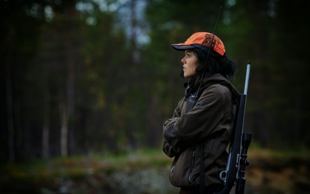 Woman hunting with a rifle slung over her shoulder
