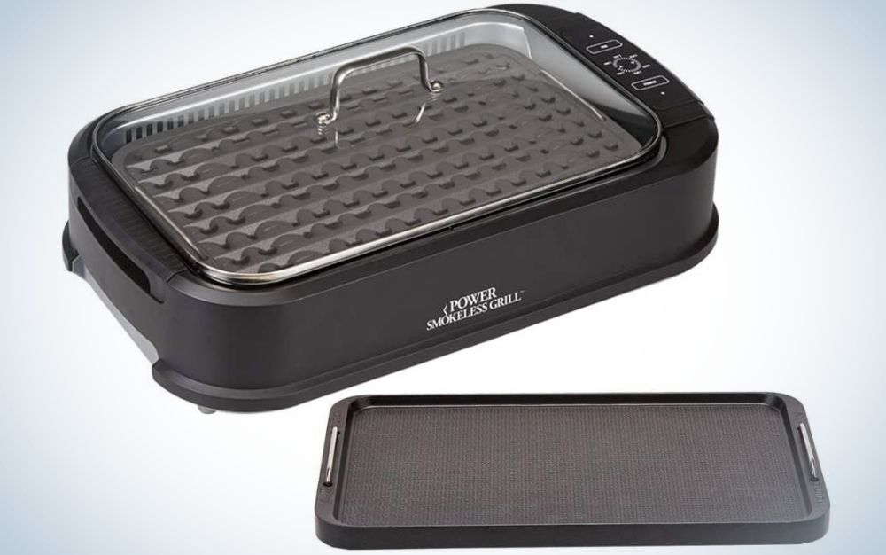 A square black grill with a gray lid and a flat black plate on the side.