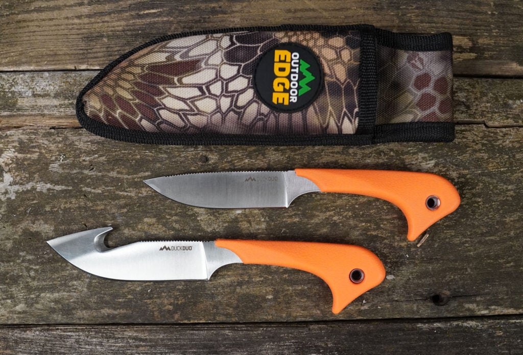 Two orange knives with a camo sheath