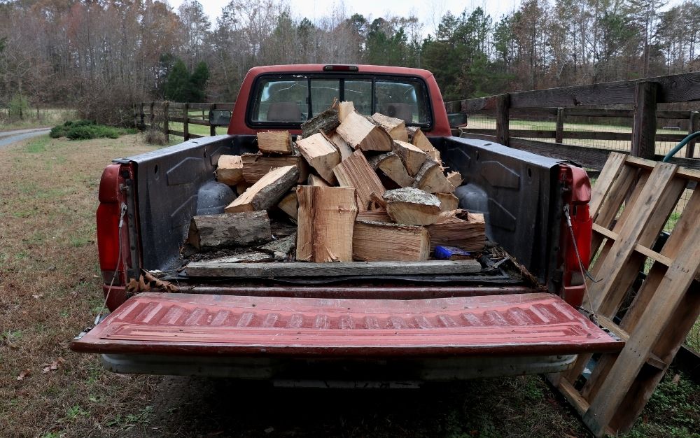 A pickup truck loaded with firewood.
