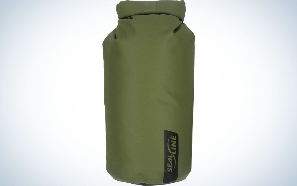 A large bag similar to a boxing bag which is green and in the shape of a cylinder.