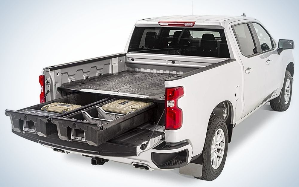 A truck which is white in color and from the back has a large space and two left heavy and complementary accessories for the car.