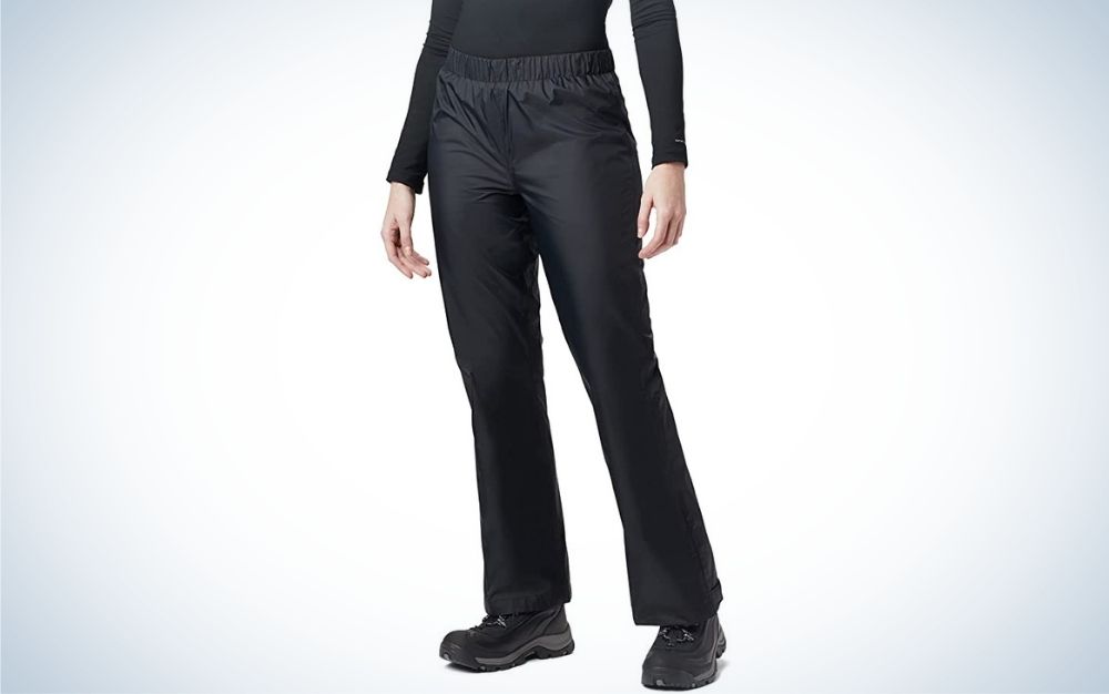 A pair of black and tight pants with little shine, which are worn by a woman in a black shirt and a pair of black sneakers as well.