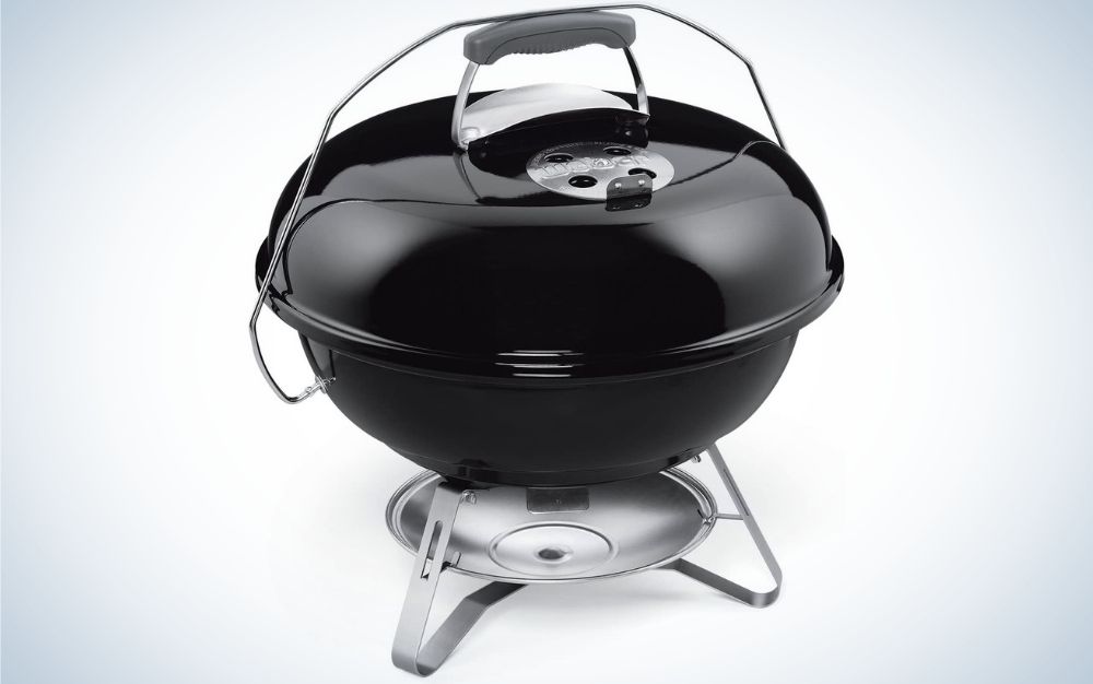 A large and wide oval grille with black color and black lid, as well as a silver and black holder under it.