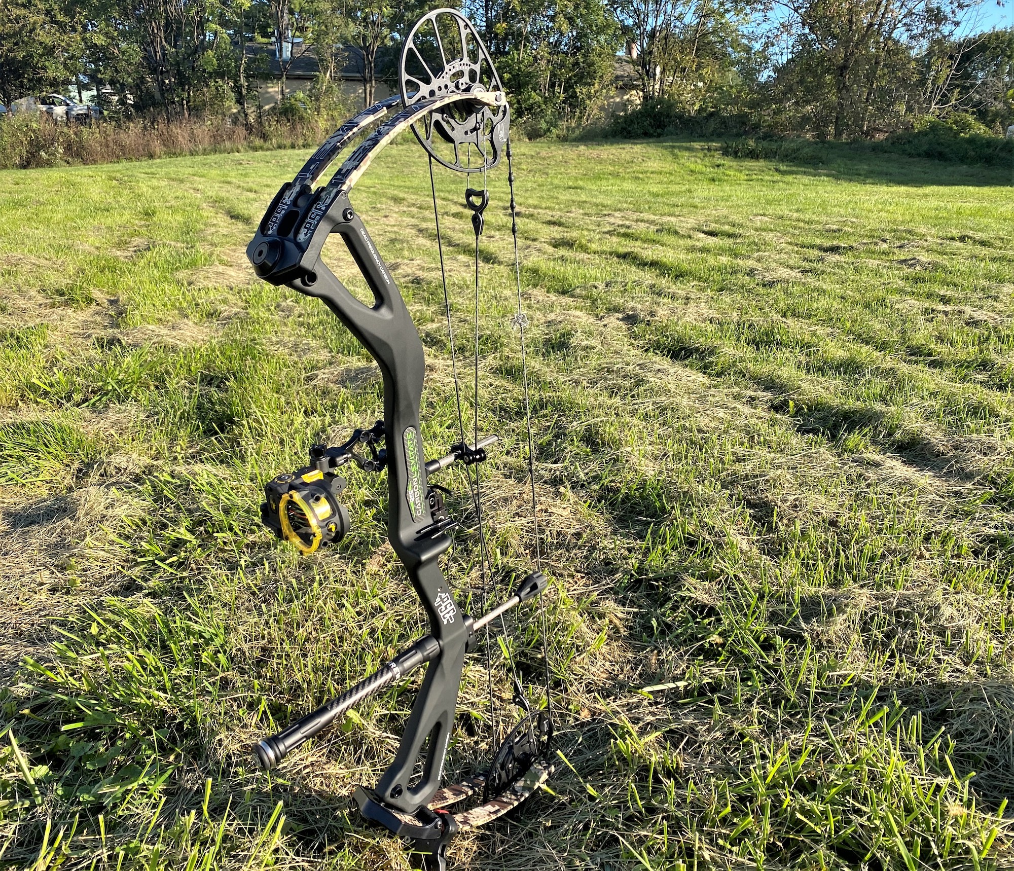 A green PSE Levitate bow standing up in a field