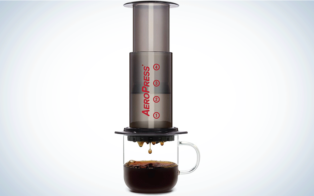 An AeroPress filter pressing coffee into a mug