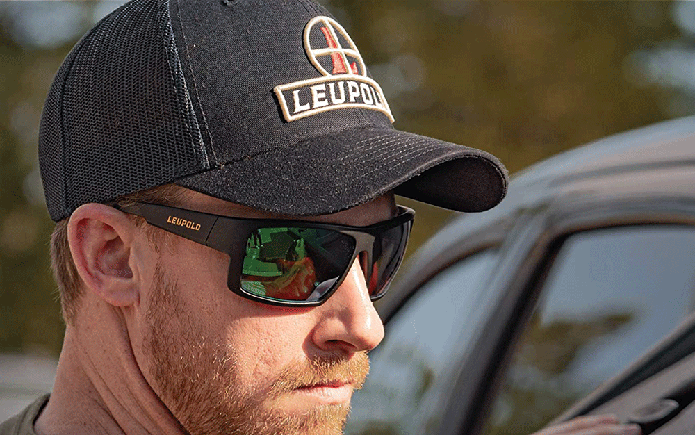 A man wearing sunglasses in a black hat