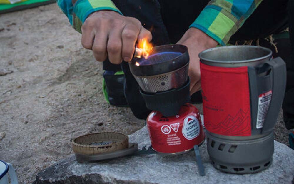 Hands lighting a backpacking stove