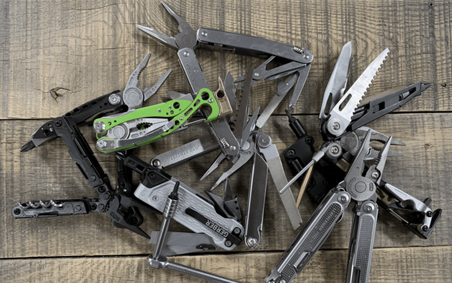 A pile of multi tools on a wooden surface