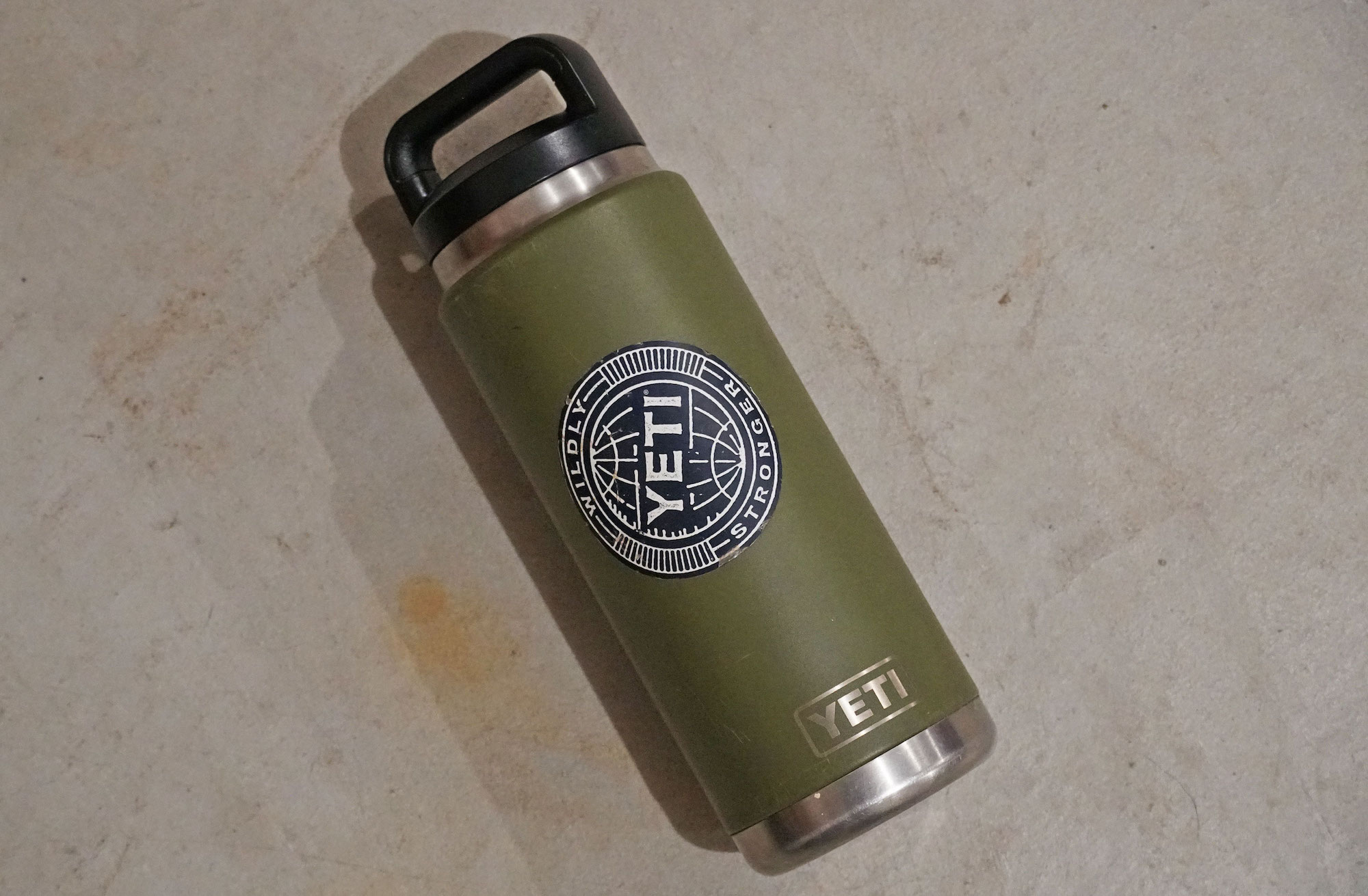 A green YETI Rambler thermos with a black cap